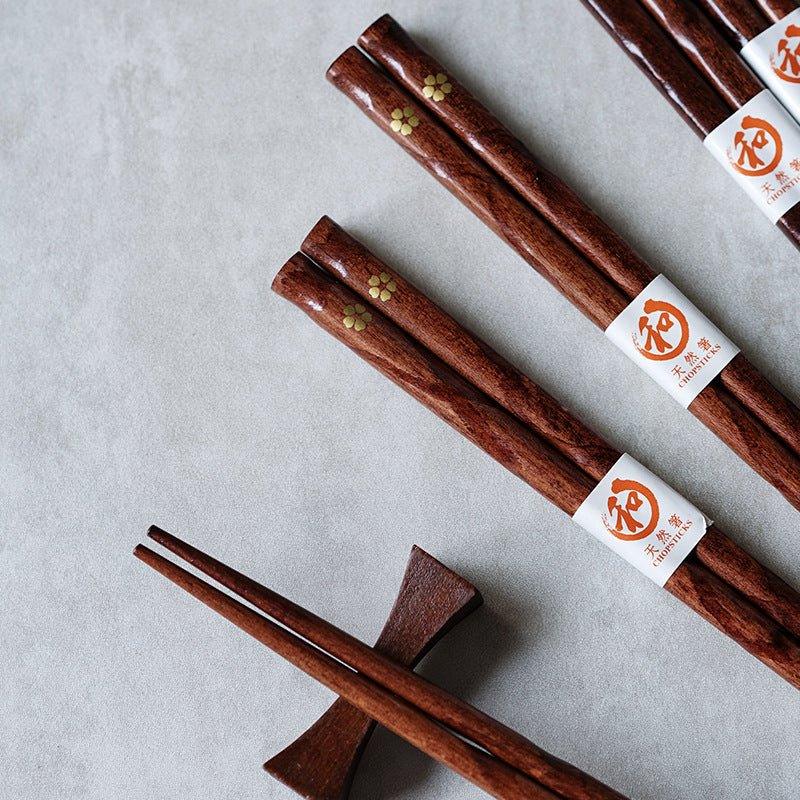 Japanese wood chopsticks with delicate golden cherry blossom design, perfect elegant tableware.