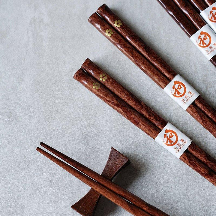 Japanese wood chopsticks with delicate golden cherry blossom design, perfect elegant tableware.