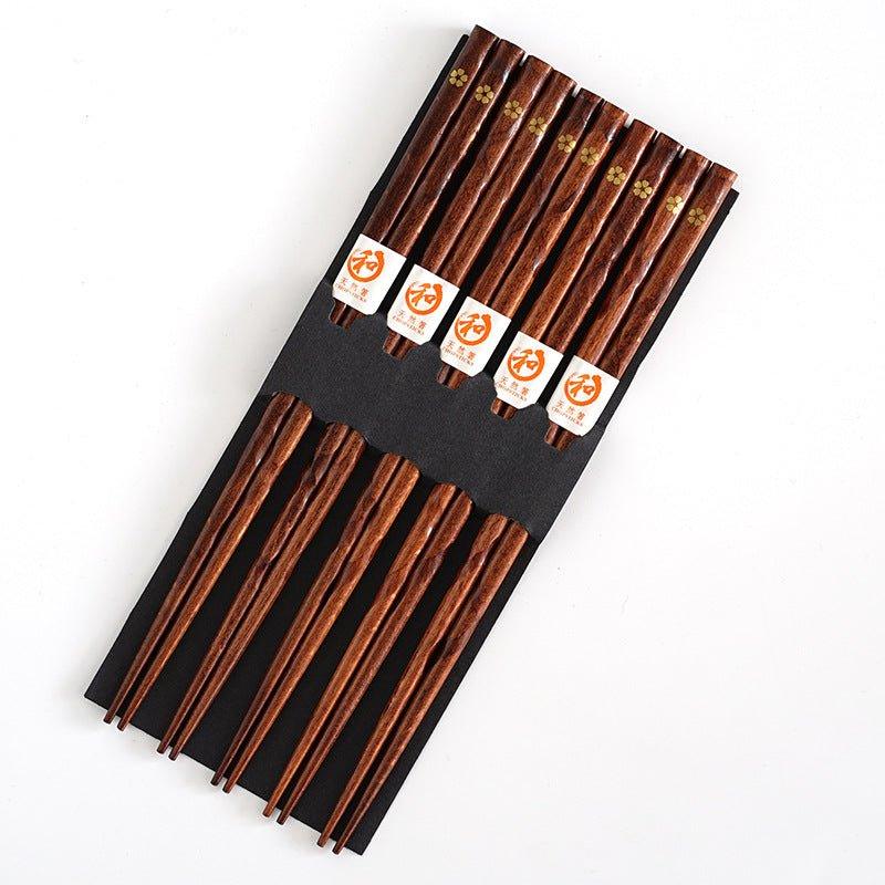 Close-up: Elegant wooden chopstick featuring golden cherry blossom art, enhancing any Japanese dining experience.
