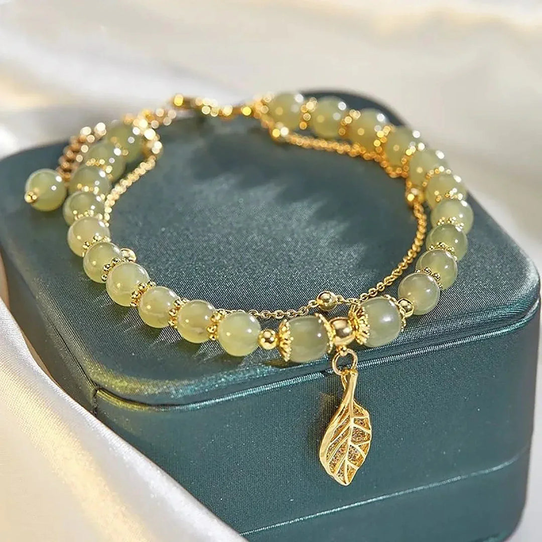 Close-up of a women's adjustable green jade bracelet featuring a delicate leaf design. Natural stone elegance.