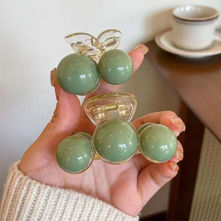 Elegant green pearl hair clip with gold accents, ideal for a stylish women's updo. Chic hair accessory.