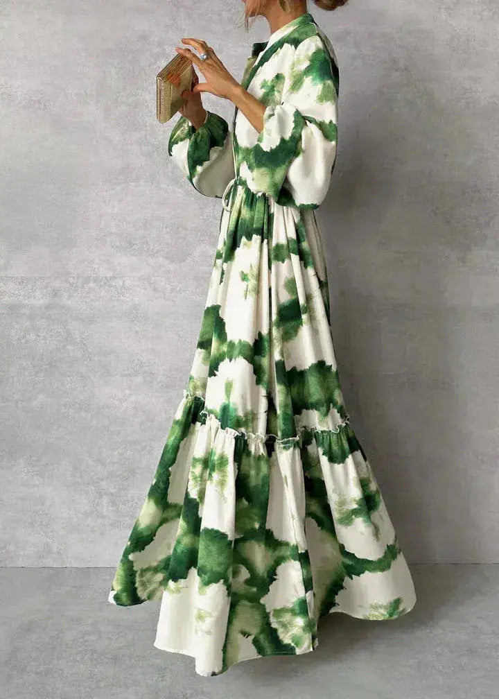 Flowy white women's maxi dress. Features puff sleeves, V-neck, tiered skirt, and tie waist. Ideal evening gown.