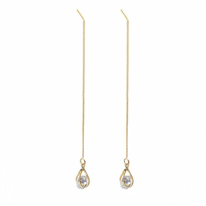 Close-up of intricate long drop rhinestone dangle earrings, elegant womens fashion accessory.