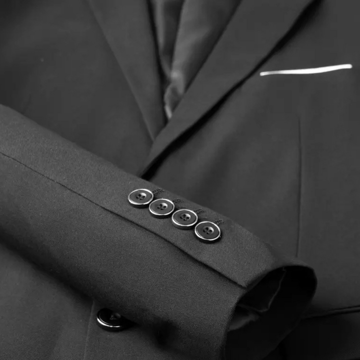Close-up of a men's elegant three-piece suit, showing tailored lapel, vest, and premium fabric. Formal business wear.