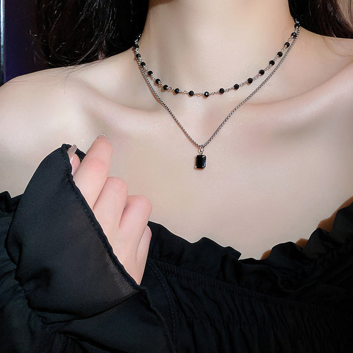 Elegant silver double chain necklace for women, featuring a black pearl. Perfect adjustable fashion accessory.