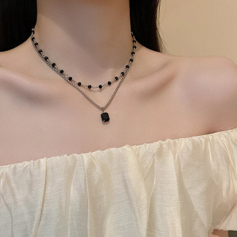 Stunning women's silver double chain necklace with a black pearl, ideal elegant jewelry and statement piece.
