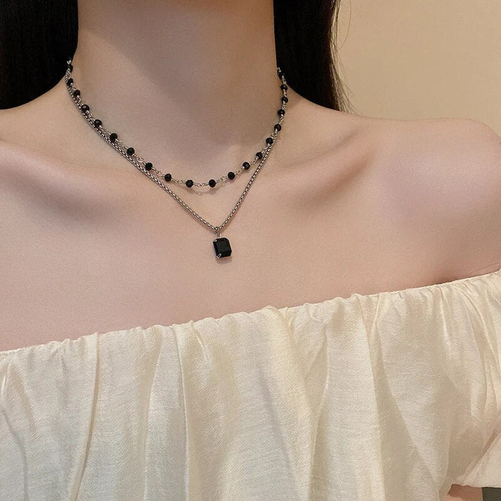 Stunning women's silver double chain necklace with a black pearl, ideal elegant jewelry and statement piece.