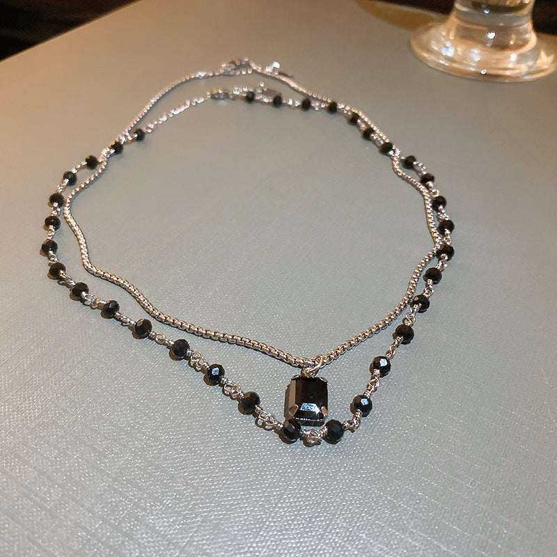 Fashionable silver double chain necklace, an elegant black pearl women's jewelry piece. Adjustable for perfect fit.