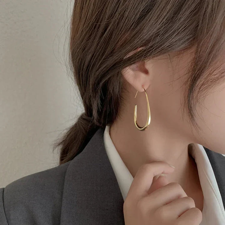 Elegant silver fluid hoop earrings for women, lightweight & hypoallergenic for sensitive ears. Perfect for everyday comfort.