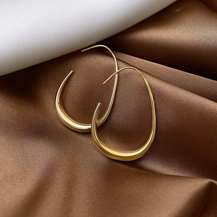Lightweight silver fluid hoop earrings with a comfortable, elegant design for women. Ideal for sensitive ears.