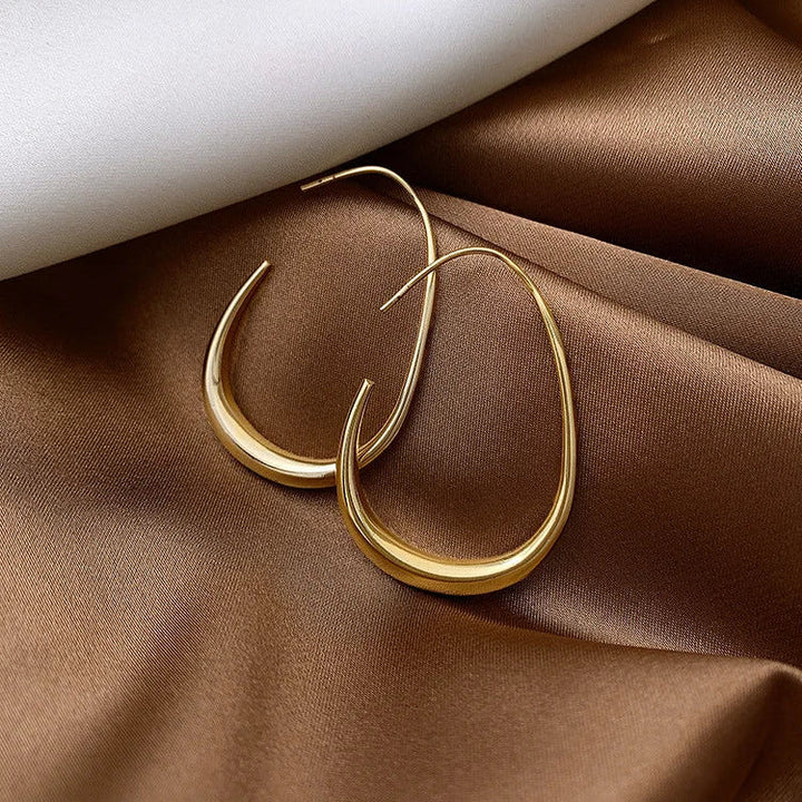 Lightweight silver fluid hoop earrings with a comfortable, elegant design for women. Ideal for sensitive ears.
