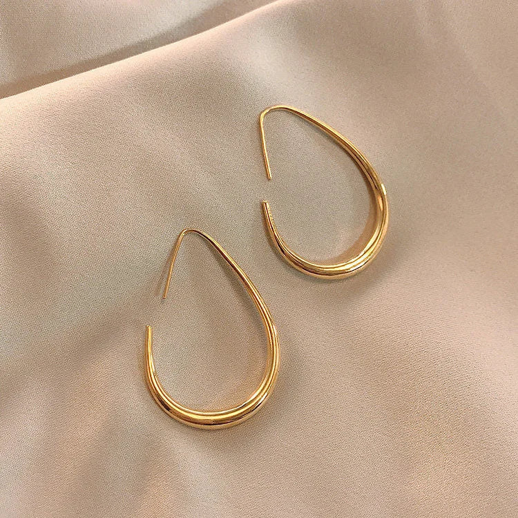 Versatile women's fluid hoop earrings, silver-toned & lightweight. Hypoallergenic design ensures comfort for sensitive ears.