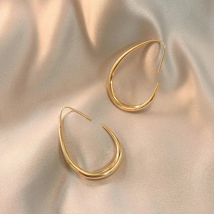 Chic silver fluid hoop earrings, ultra-lightweight and comfortable. Designed for women with sensitive ears, perfect for daily wear.