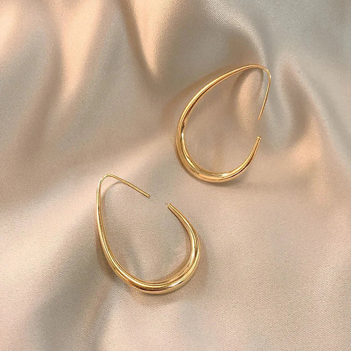 Chic silver fluid hoop earrings, ultra-lightweight and comfortable. Designed for women with sensitive ears, perfect for daily wear.