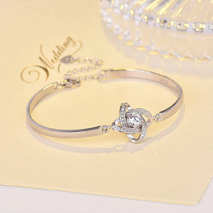 Close-up of a delicate love knot bracelet for women with an elegant, adjustable stainless steel chain.