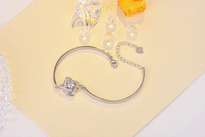 Woman wearing an elegant love knot bracelet on her wrist, adjustable silver-tone chain jewelry.