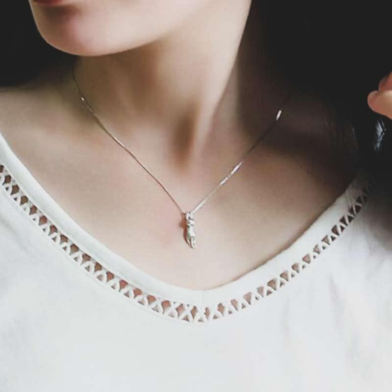 Close-up of a shimmering sterling silver cat pendant necklace, showcasing intricate feline design.