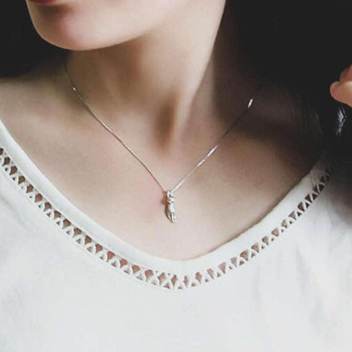 Close-up of a shimmering sterling silver cat pendant necklace, showcasing intricate feline design.
