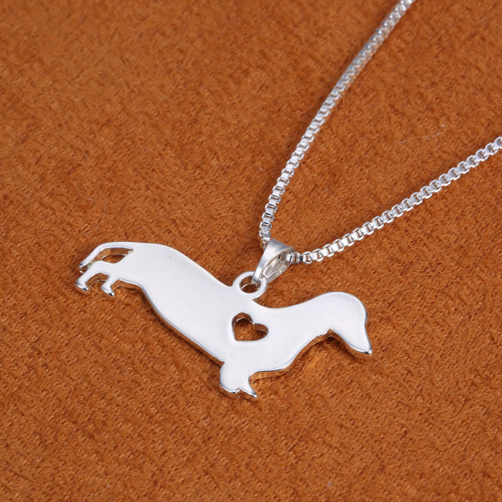 Close-up of a sterling silver dachshund and heart pendant, a charming women's necklace for dog lovers.