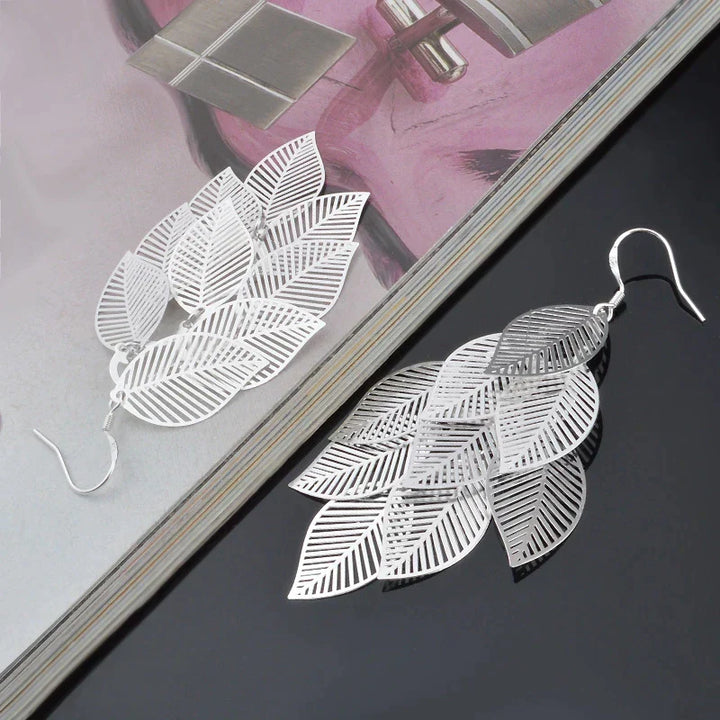 Women's elegant layered leaf earrings, delicate sterling silver dangle design. Nature-inspired jewelry.