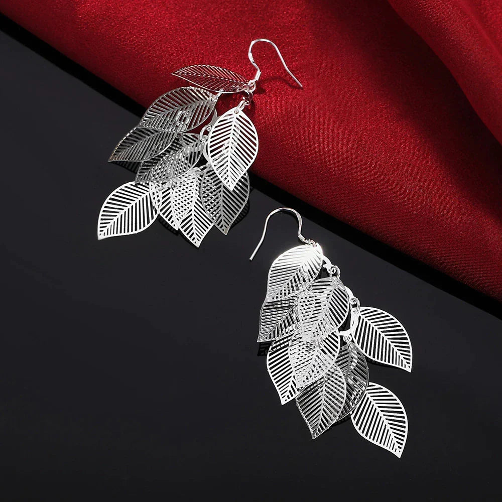 Sterling silver delicate layered leaf dangle earrings for women. Elegant, nature-inspired fine jewelry.