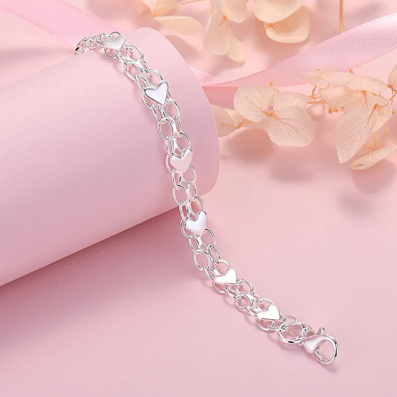 Close-up of a women's sterling silver heart bracelet, showcasing its classic elegance and adjustable design. Fine jewelry gift.