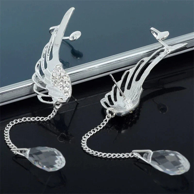 Close-up of elegant women's sterling silver angel wing long cuff earrings. Fashion jewelry.