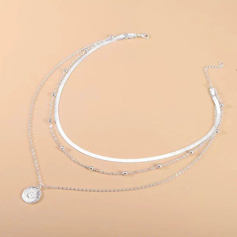 Stylish women's silver layered triple chain necklace, adding a sophisticated touch to any outfit.