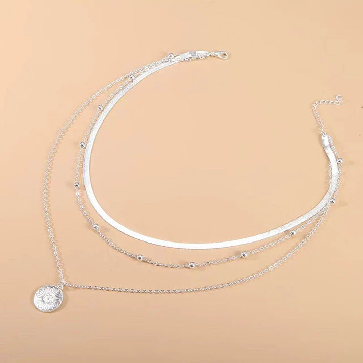 Stylish women's silver layered triple chain necklace, adding a sophisticated touch to any outfit.