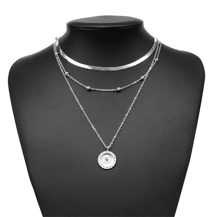 Close-up of a shimmering sterling silver triple chain necklace, delicate and fashionable jewelry.