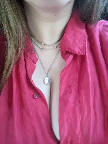 Woman wearing an elegant silver triple chain necklace, a versatile fashion accessory and gift.