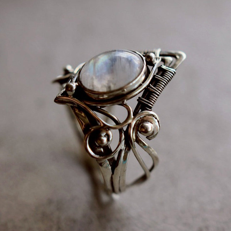 Close-up of a women's vintage moonstone ring, showcasing the silver setting & gemstone's unique shimmer.