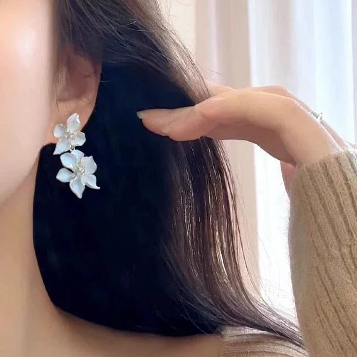 Elegant white flower drop earrings for women, featuring delicate floral design & silver accents, a stylish fashion accessory.