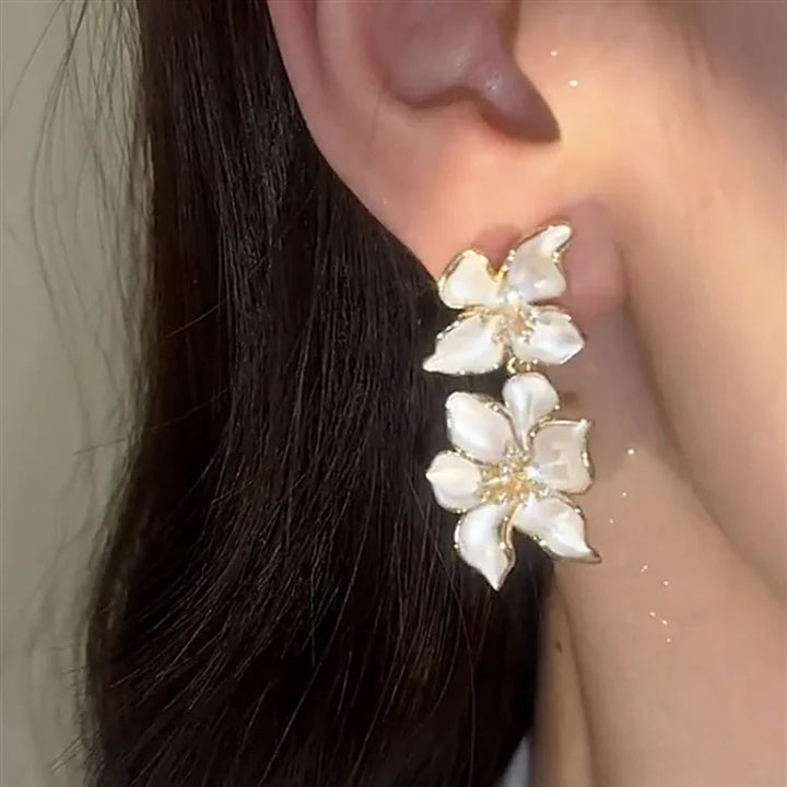 Women's elegant white flower drop earrings, delicate silver floral jewelry, a beautiful and nature-inspired accessory.