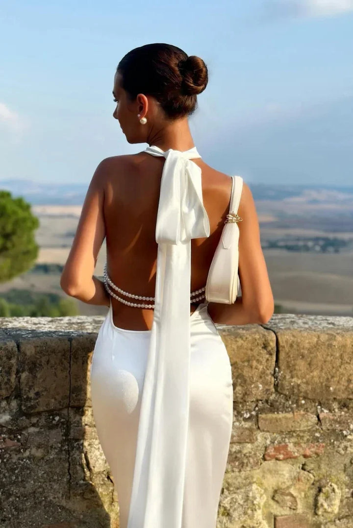 Glamorous women's backless halter maxi dress in white, ideal for evening wear & vacation style.