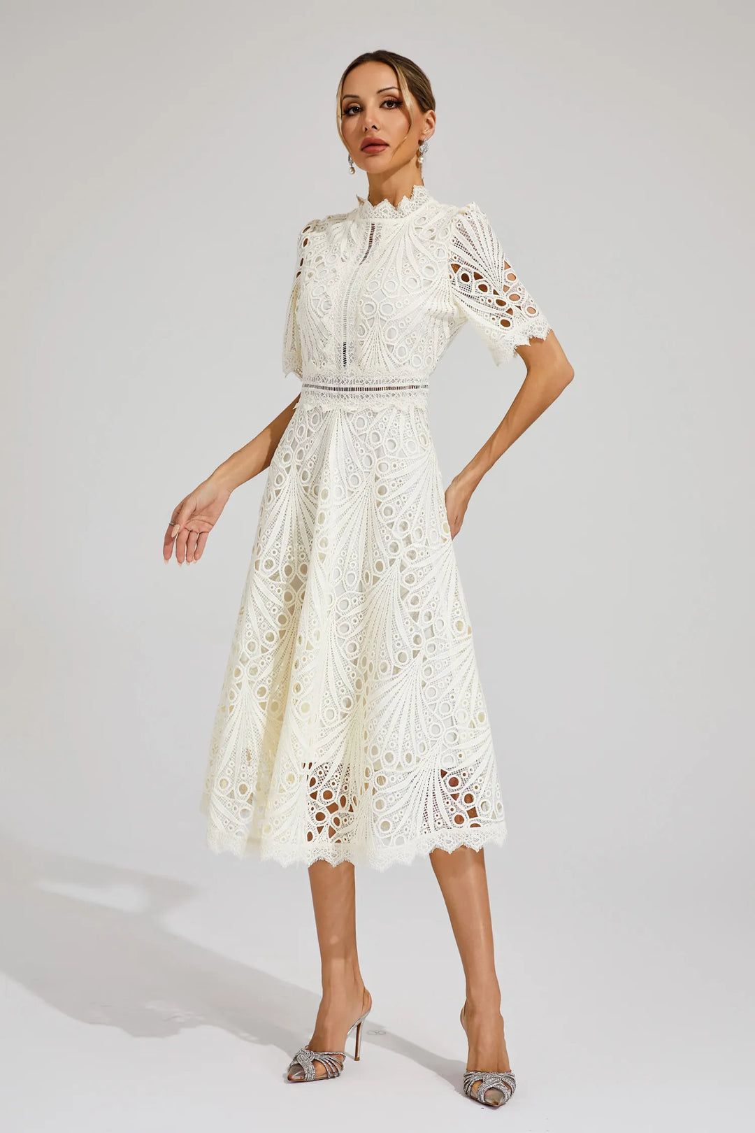 Close-up of intricate lace detail on an elegant white women's midi dress.
