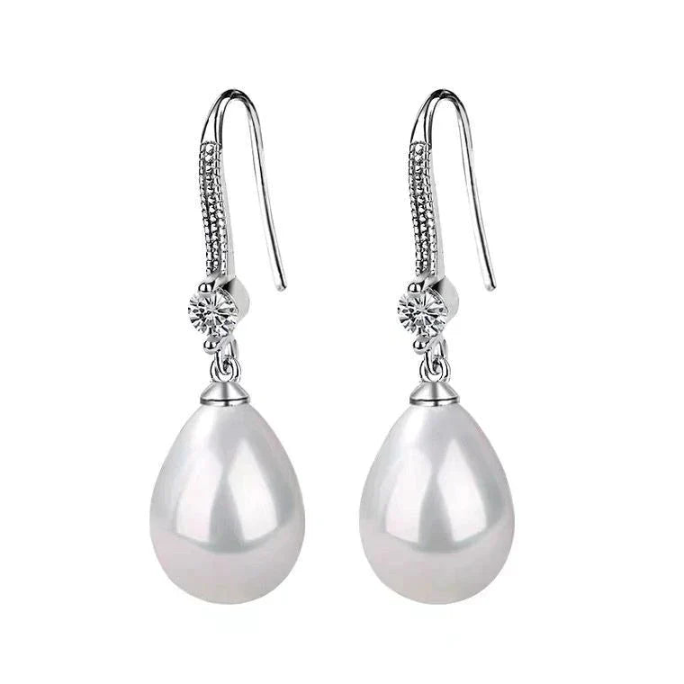 Elegant white oval pearl drop earrings for women, featuring lustrous pearls and sterling silver hooks. Timeless classic.