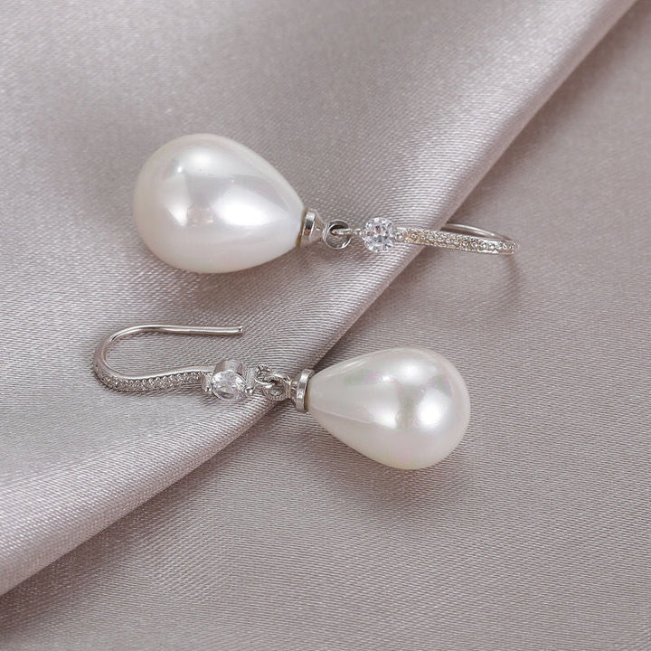Timeless elegant white oval pearl drop earrings. Lustrous oval pearls on sterling silver hooks for women's jewelry.