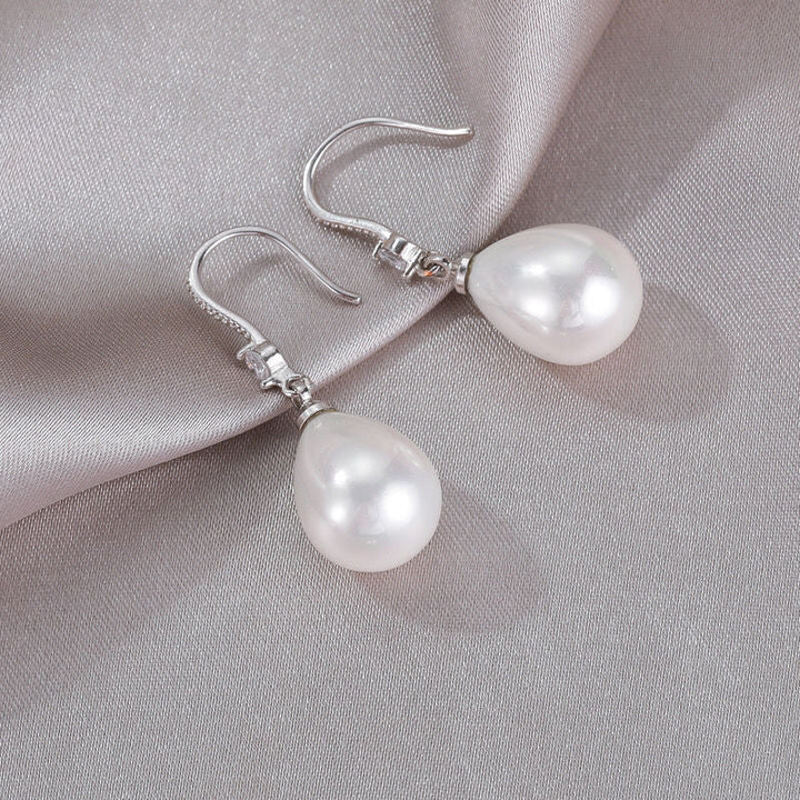 Beautiful white oval pearl drop earrings for women. Elegant sterling silver design, perfect classic jewelry gift.