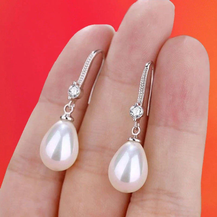 Close-up of elegant white oval pearl earrings, showcasing the lustrous oval pearls and sterling silver setting.