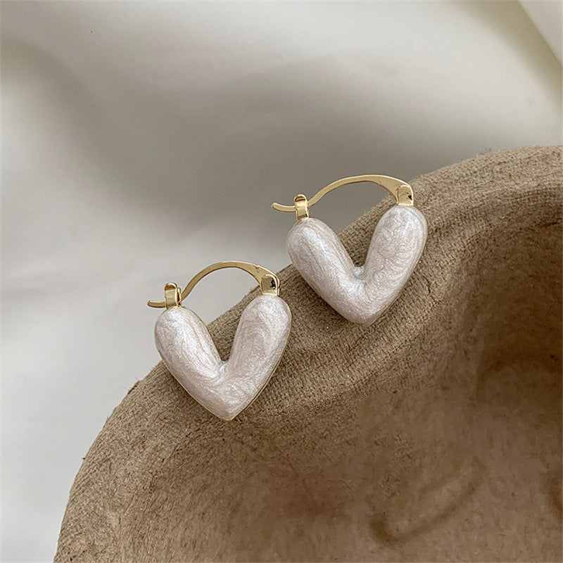 Chic women's white teardrop dangle earrings. Elegant gold-plated Love Collection fashion jewelry accessory.
