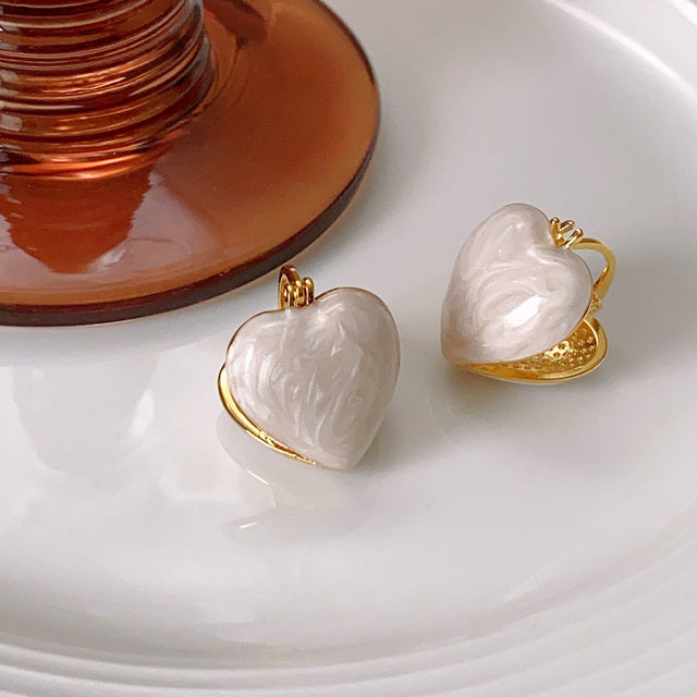 Fashionable women's white teardrop dangle earrings. Elegant gold-plated love-inspired jewelry accessory.