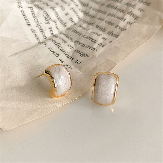 Beautiful white teardrop dangle earrings, love-inspired design. Elegant gold-plated women's jewelry.