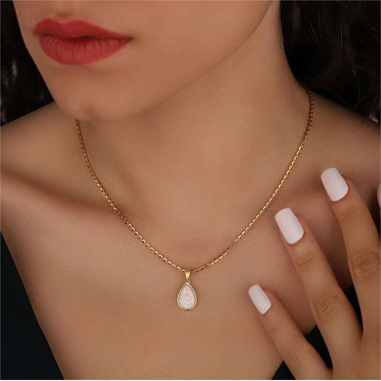 Close-up of a women's 18K gold pendant necklace showcasing a beautiful natural opal gemstone.