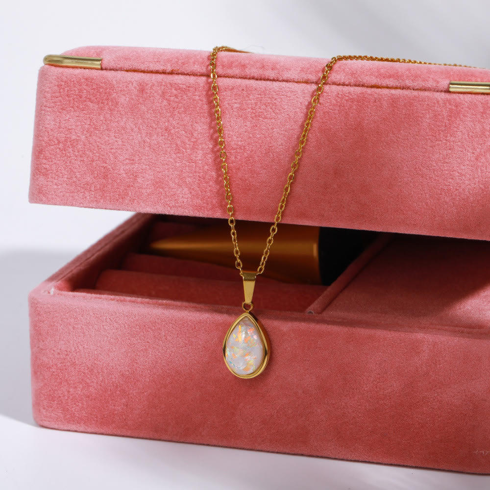 Display of a women's 18K gold necklace with a lustrous natural opal drop pendant. Perfect gift.