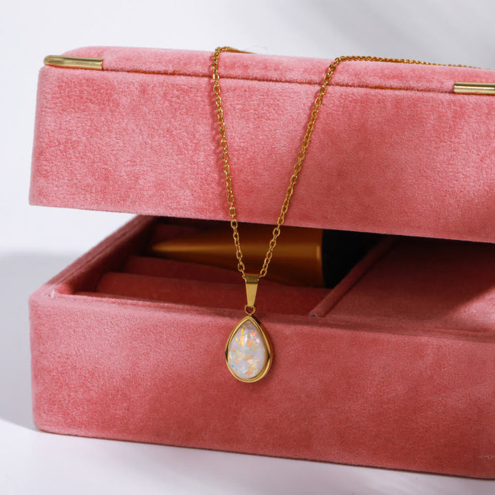 Display of a women's 18K gold necklace with a lustrous natural opal drop pendant. Perfect gift.