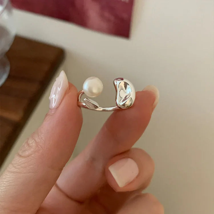 Close-up of an elegant women's adjustable silver ring showcasing a natural pearl and intricate tree design.