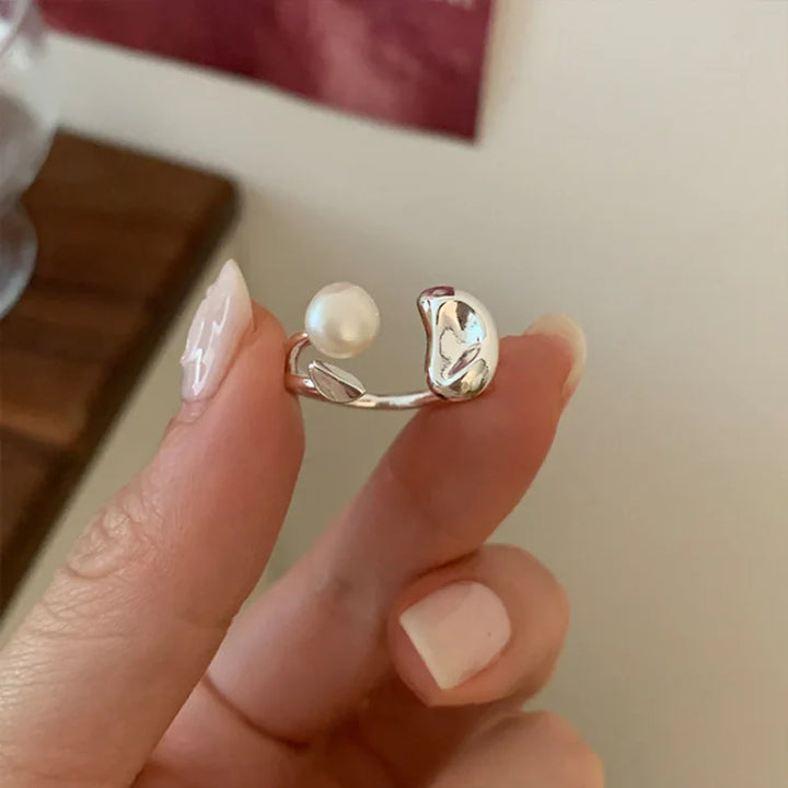 Close-up of an elegant women's adjustable silver ring showcasing a natural pearl and intricate tree design.