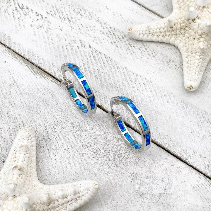 Elegant women's adjustable silver ring featuring a shimmering blue opal, handcrafted ocean-inspired jewelry.