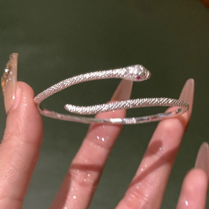 Women's silver snake bracelet gracefully worn on a wrist, showcasing its elegant and adjustable design.